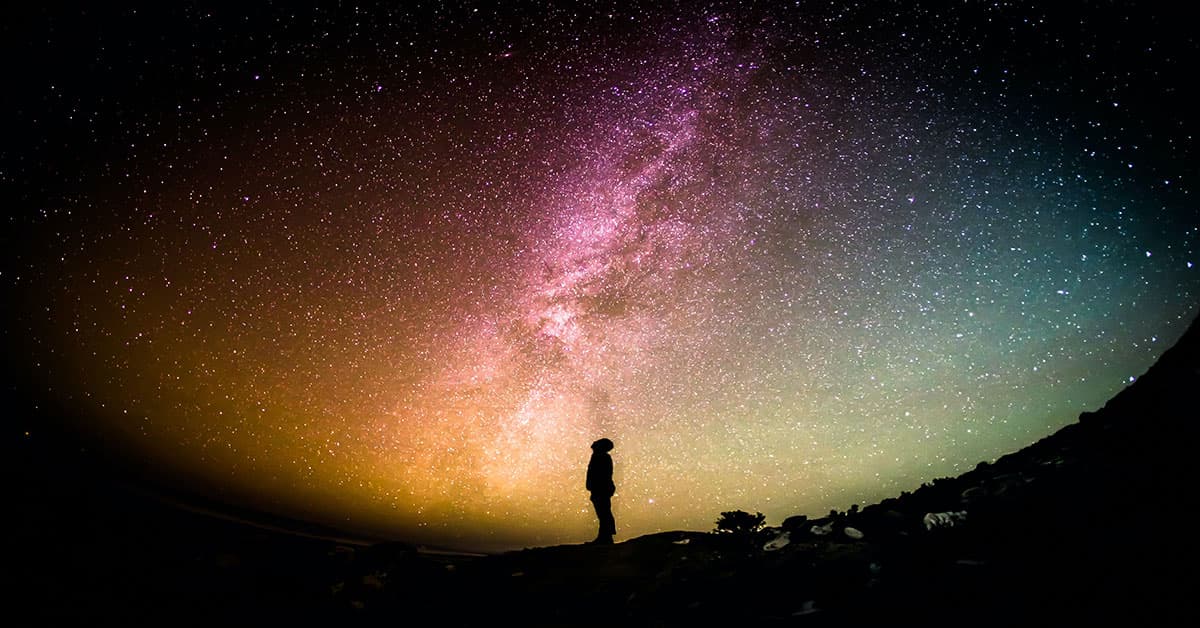 silhouette-of-a-man-standing-on-a-hill-looking-up-at-the-milky-way